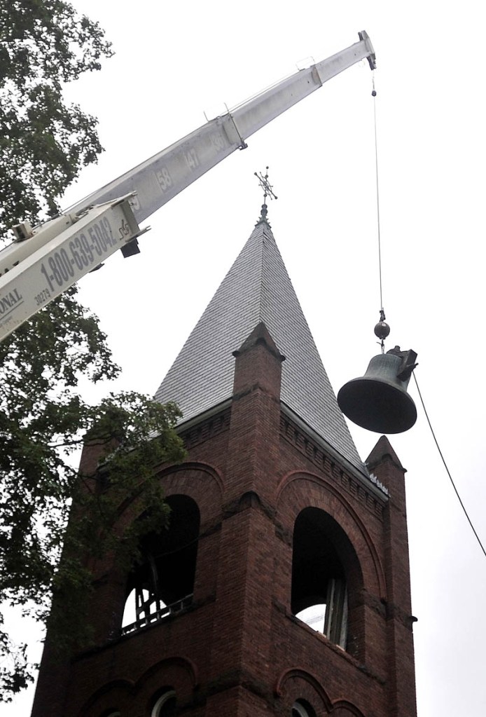 A crane from MMR Professional Steeplejacks, hoist the 100-year-old Meneely bell from the belfry of the Old South Congregational Church on Main Street in Farmington Wednesday morning.