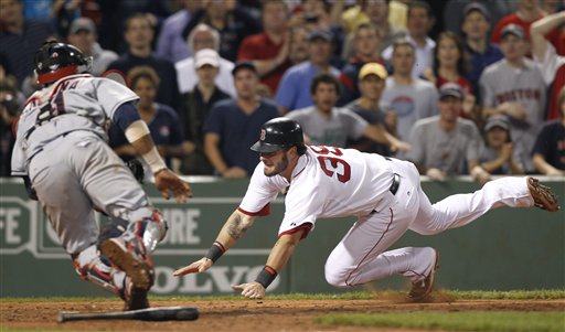 Boston Red Sox's Jarrod Saltalamacchia dives for home plate to score the winning run as Cleveland Indians catcher Carlos Santana tries to tag him in the ninth inning Tuesday at Fenway Park in Boston. The Red Sox won 3-2.