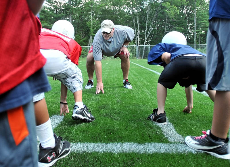 Former New York Jets defensive lineman Marty Lyons works with a group of local football players at Camp Tracy in Oakland Friday.