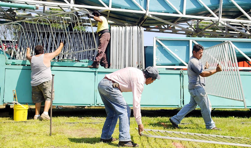 Workers assemble a Rockwell Amusements ride Monday on the fairway at the Monmouth Fairgrounds. The Cochnewagan Agricultural Society's annual festival commences Wednesday and concludes Saturday.