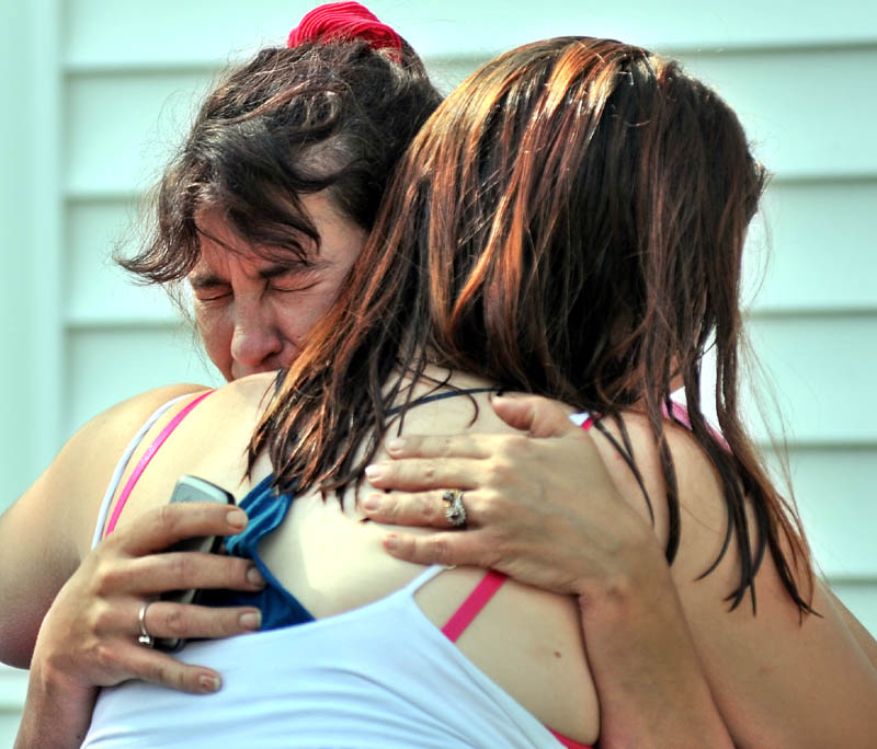 Staff photo by Michael G. Seamans Tracy Bragdon, front left, owner of the Oak Street home destroyed by fire Tuesday morning is consoled by a friend as Forty firefighters from four agencies, Waterville, Winslow, Fairfield and Oakland Fire Departments battle the blaze. No injuries were reported.