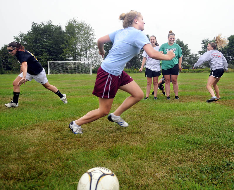 TEAM BUILDING: Richmond High School girls soccer players chase each other across the field Monday during the defending Class D champions first day of practice. Athletes at schools across Maine took to soggy fields for the commencement of the 2011-2012 high school sports season.