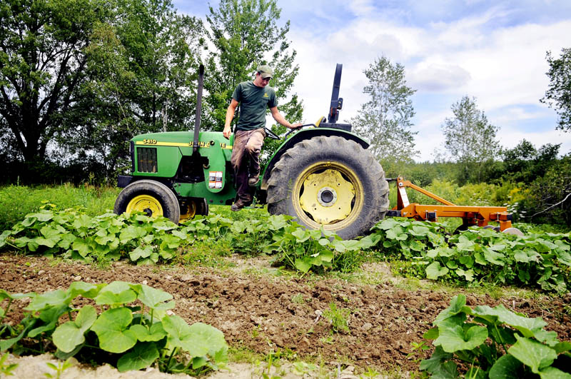 Steve Christianson dismounts a tractor after harrowing a summer squash patch Tuesday in Mount Vernon. The manager of Belle Vue Farm, in Readfield, was relieved to learn that the federal government Wednesday scrapped plans to require farmers to get commercial drivers licenses to operate their tractors.