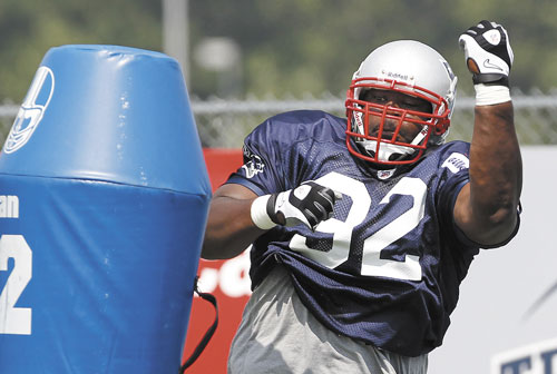 COMING THROUGH: New England Patriots defensive lineman Albert Haynesworth takes on a blocking dummy during training camp Tuesday in Foxborough, Mass.