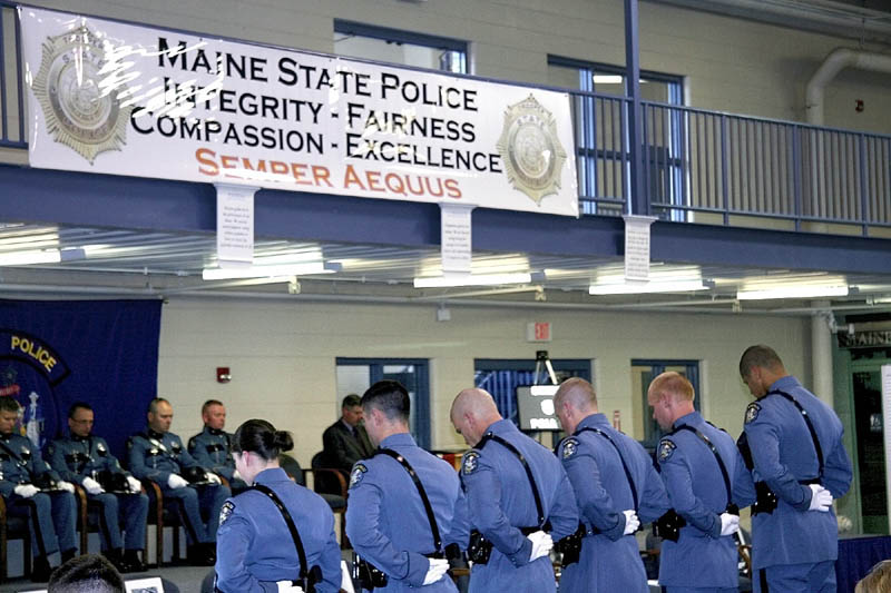 New state troopers bow their heads during the benediction at their ceremony Friday afternoon at the Maine State Criminal Justice Academy in Vassalborough.