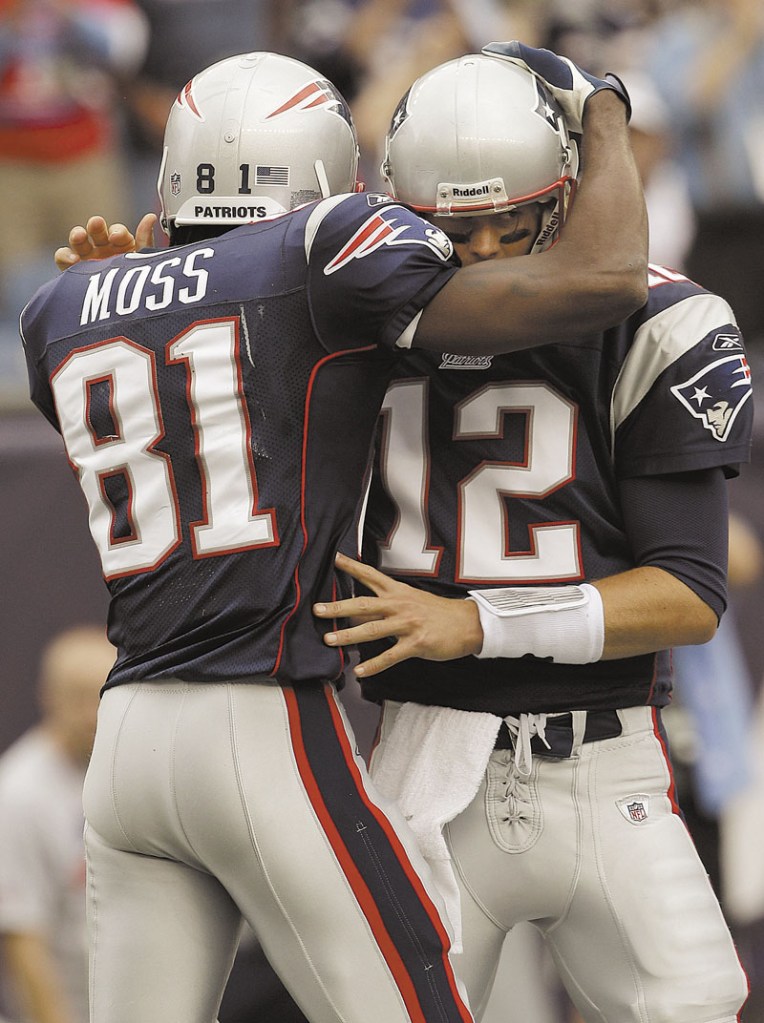 GOODBYE: New England Patriots quarterback Tom Brady (12) hugs wide receiver Randy Moss on Sunday, Sept. 26, 2010. Moss, who caught an NFL-record 23 touchdowns for the Patriots in 2007, will retire, according to his agent.