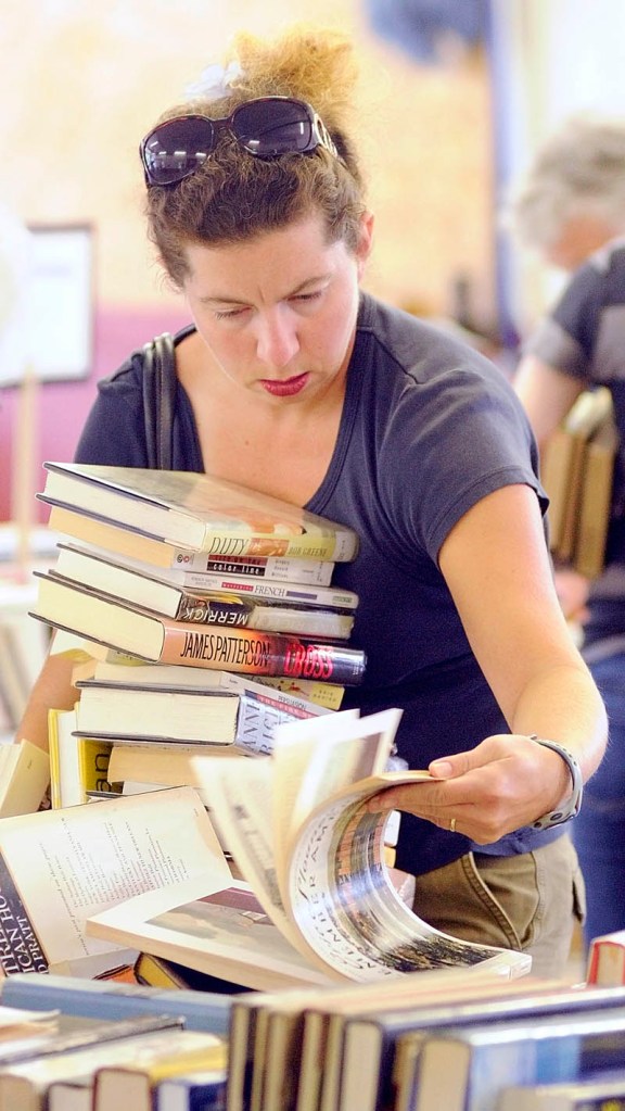 Diona Lovejoy, of Morgantown, Penn., searches for more books at the Readfield Community Library used book sale on Saturday morning during Readfield Heritage Days. The event was held across the street from the library in the Readfield fire station.