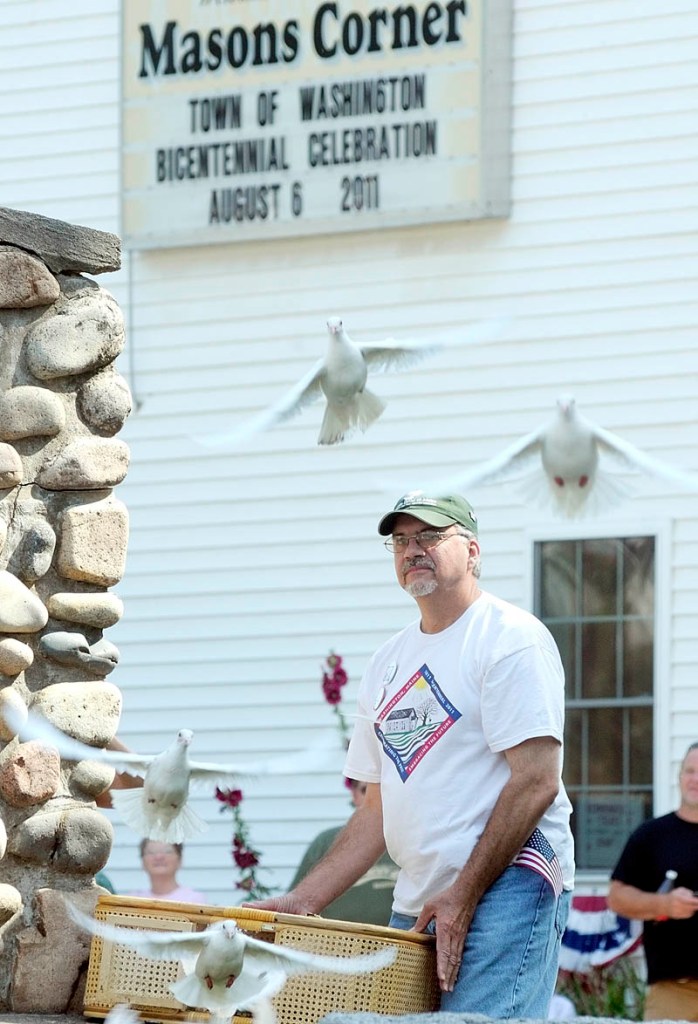 Marc Archambault, of White Doves of Maine, releases a basketful of doves before the parade to celebrate the Town Of Washington's bicentennial on Saturday.