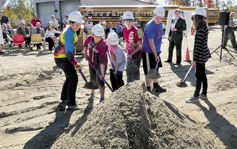WOOD SPLITTERS: Regional School Unit 18 Superintendent Gary Smith, right, watches as students take part in a groundbreaking ceremony for the Central Biomass Boiler project near the bus garage in Oakland on Tuesday. Students from left are Sydni Collier, Grace Bourgoin, Robert Haldeman, Tristan Friend, Chandler Dugal and Emma Cyr.