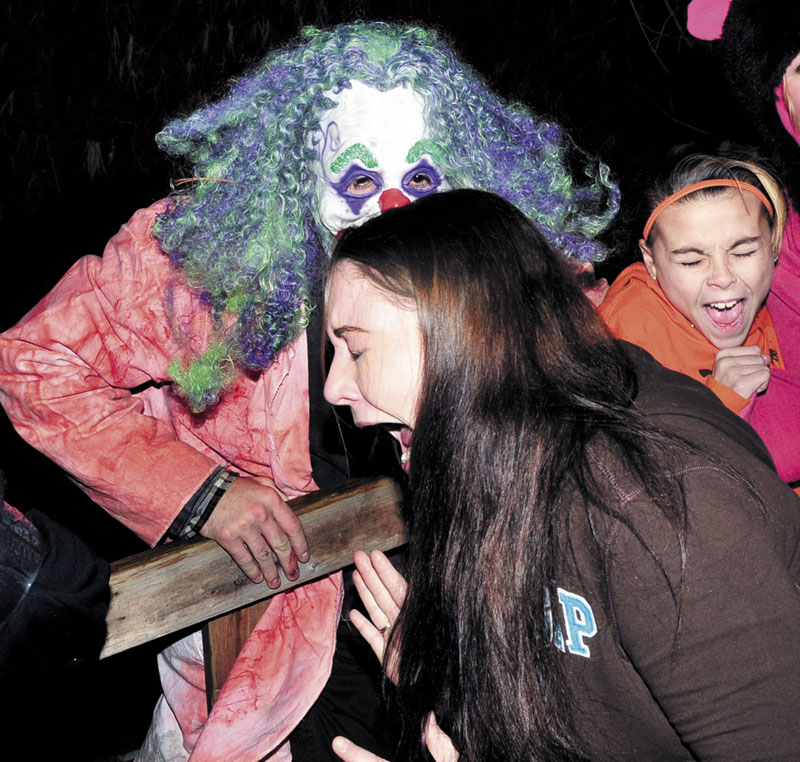 NOT FUNNY: Kids scream in fear as David Cannon jumps toward them in a demented clown outfit as up to 500 people walked the haunted trail at the Larry and Tammie Bailey home on the Canaan Road in Clinton last weekend.