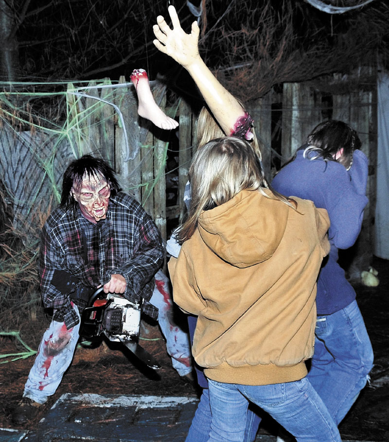 I'LL HAVE A LEG: Dressed up as a chainsaw- wielding zombie, Larry Bailey jumps out from the dark at people who dared walk through a haunted trail at his home at 449 Canaan Road in Clinton. The popular Halloween attraction will be open this Saturday at 7:30 p.m.