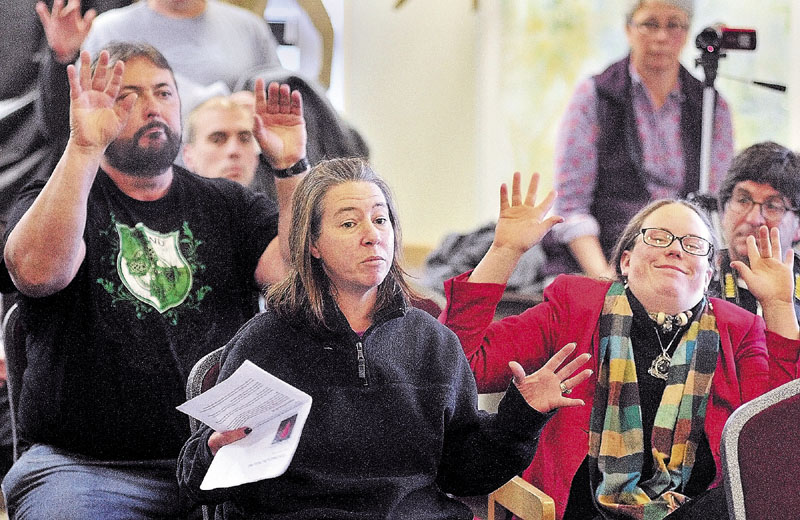 PROTESTERS: Kim Tripp, center, speaks during an Occupy Maine forum on Thursday afternoon at the University of Maine at Augusta. Joseph Kane, left, and Demi Colby wave their hands in a gesture to show approval of what she was saying.