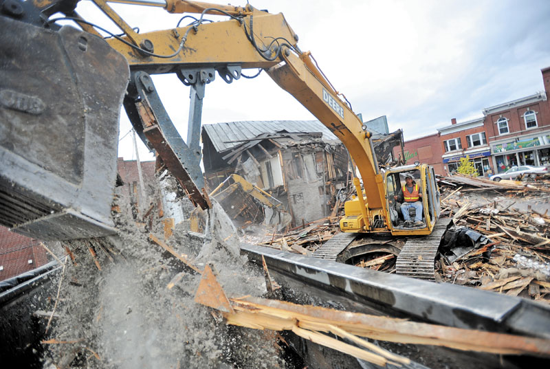 WRECKING CREW: Bruce Obert loads buckets of rubble during the demolition of several vacant buildings in downtown Skowhegan Saturday morning.