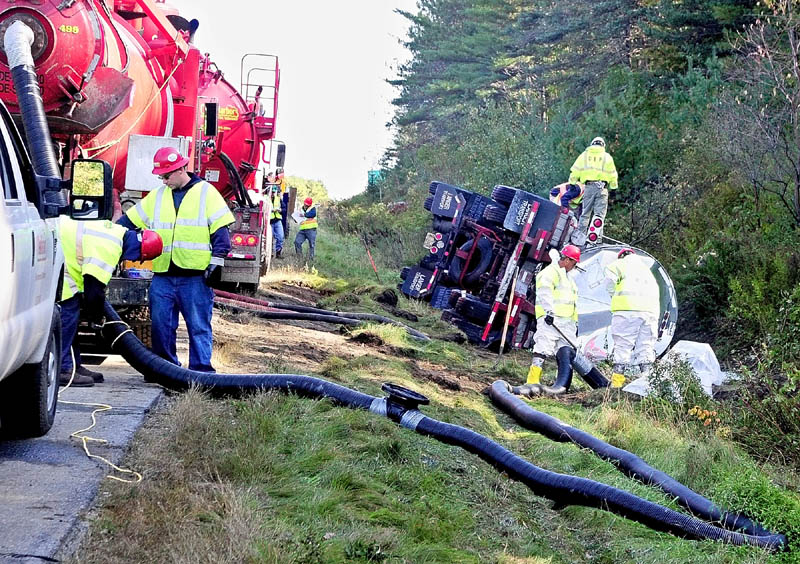 Workers pump up liquid that spilled out of tanker truck that crashed into the ditch of the north bound lane of Interstate 95 near exit 112 this morning in Augusta.