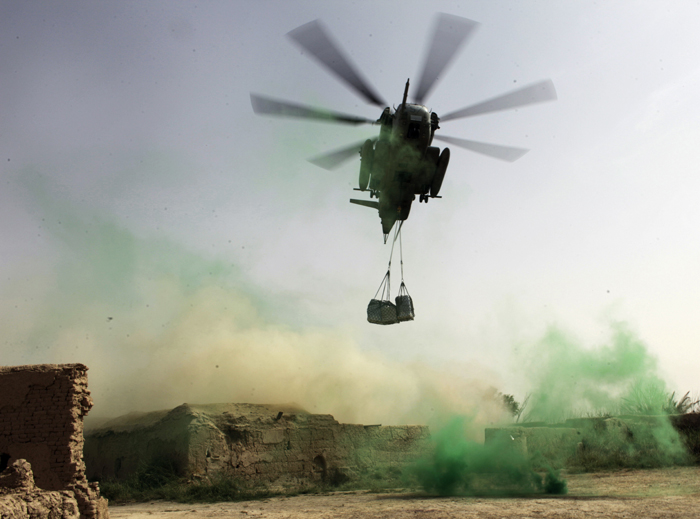 A U.S. military helicopter prepares to drop a pallet of supplies inside a Marine Corps outpost in Helmand province, southern Afghanistan.