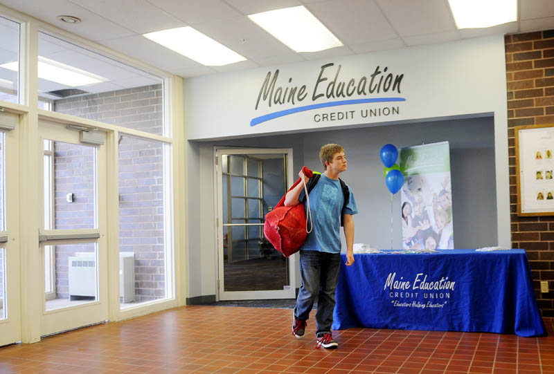 REAL EXPERIENCE: Cony High School sophomore Joe Wathen carries his football gear Tuesday as he leaves the new branch of the Maine Education Association Credit Union at the Capital Area Technical Center in Augusta. Wathen’s mother, Kelley, is operations manager at the credit union.