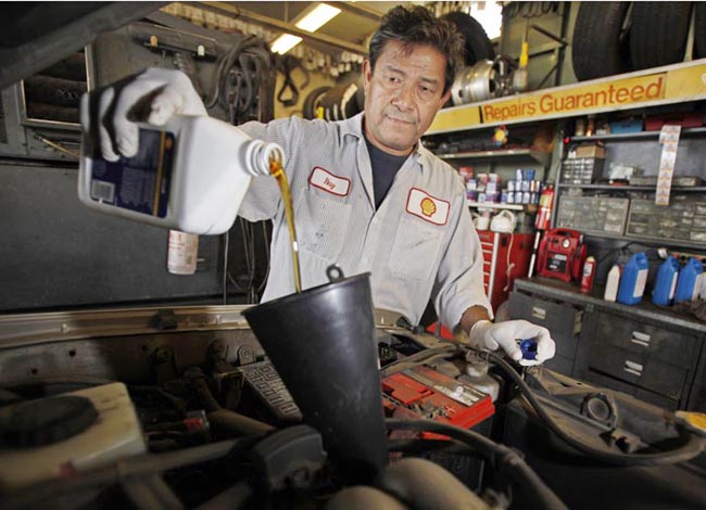 Mechanic Ray Duran changes oil in a car at a Shell station in Los Angeles. Employers added 103,000 jobs in September, a modest burst of hiring after a sluggish summer.