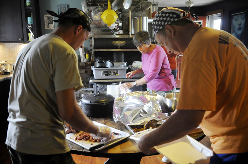 HELPING HANDS: Volunteers Heath Schwab, left, Kathy Walley and Stephen Dodge, right, prepare meals Wednesday in the kitchen of Annabessacook Farm in Winthrop. Volunteers prepare meals with local produce to feed the hungry at the farm.