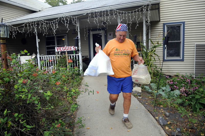 SPECIAL DELIVERY: Volunteer Stephen Dodge carries meals from Annabessacook Farm in Winthrop. Dodge — a Wayne resident who coordinates the kitchen — said he could take a $1 donation and parlay it into food worth three or four times that much.