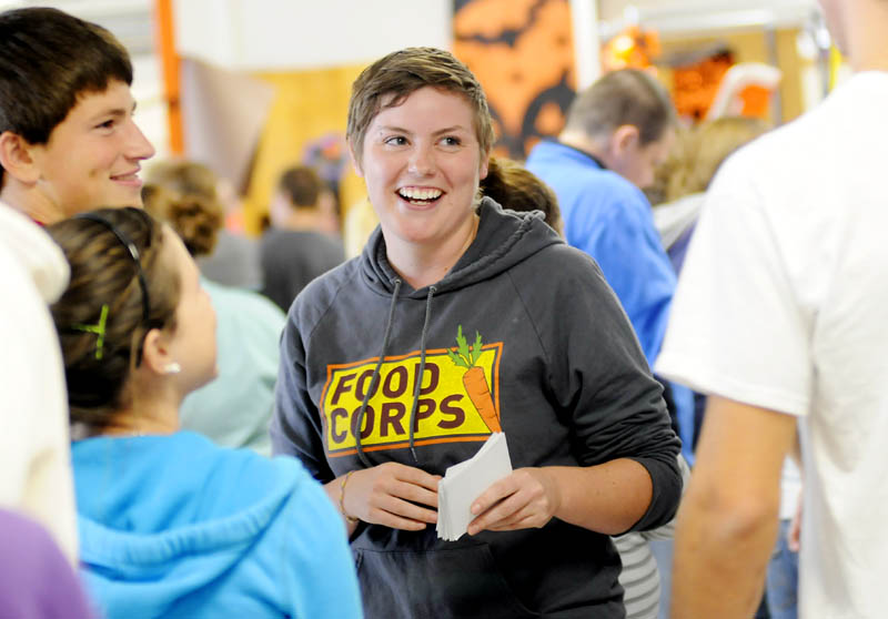 FoodCorps service member Laura Budde hands out surveys Wednesday during the Maine Harvest Lunch at Gardiner Area High School. Budde is one of 50 FoodCorps service members serving across the country and one of six in Maine during the inaugural year of the program. Budde helped organized the Maine Harvest Lunch with local food from area farmers.