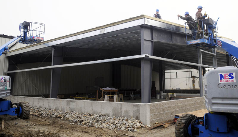 CREATING MORE SPACE: Workers from Peachey Builders build the roof Monday of the expansion to Kennebec Technologies in Augusta that Peachey is erecting. The precision machining firm is adding more space to build parts for the aerospace industry.