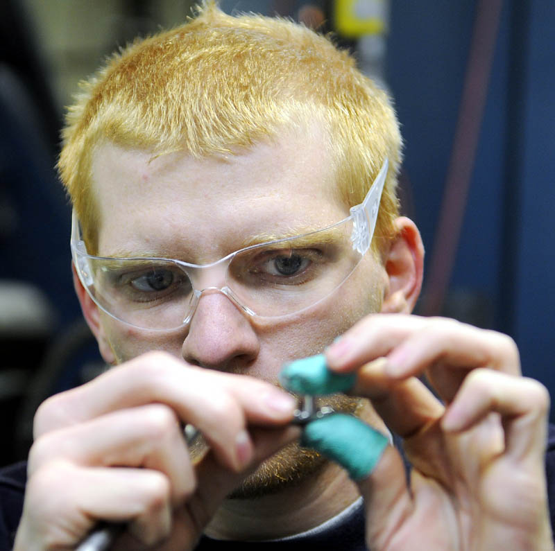 EXPANDING BUSINESS: Kennebec Technologies employee Don Poliquin inspects an anti-rotation pin Monday in the workshop at the Augusta company. The precision machining business is building an addition to process more work for the parts it builds for the aerospace industry. The company on Church Hill Road expects 12 percent growth this year and 10 percent in 2012.