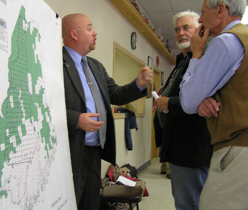 NEW RULES: Land Use and Regulatory Commission member Christopher Gardner, left, speaks with meeting attendees David Miller and Howard Trotzsky at the Solon Fire Station on Thursday.