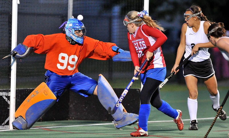 NOT GETTING IN: Messalonskee High School goalie Lexy Cole, left, blocks a shot with her head as teammate Bri Garland, center, helps defend Skowhegan’s Makaela Michonski, right, in the first half of the Class A Kennebec Valley Athletic Conference championship game Wednesday at Colby College in Waterville.