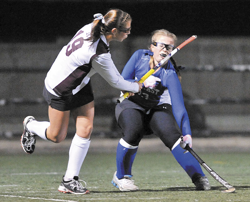 LOOK OUT: Nokomis Regional High School’s Leah Edmondson, left, hits Belfast High School’s Kristi Osgood in the head with her follow through swing in the first half of the Eastern B championship game Tuesday at the Weatherbee Complex in Hampden.