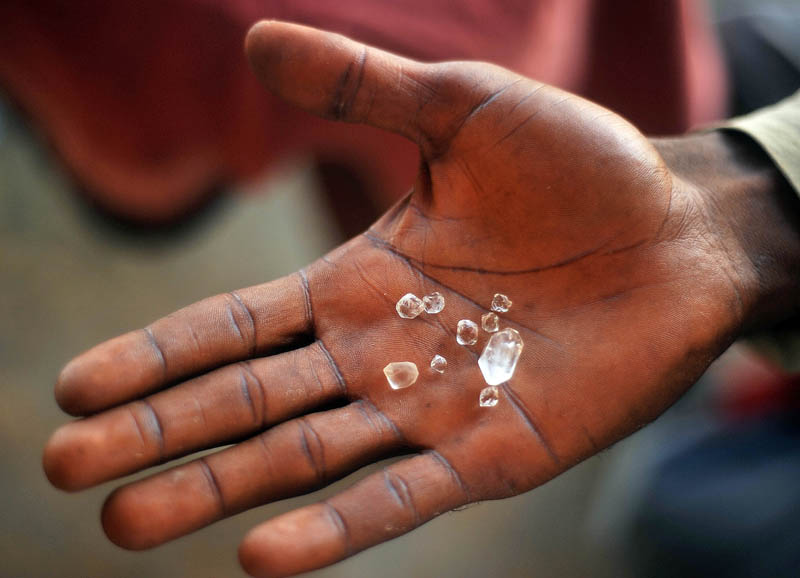 Alpha, a local peddler of goods in Lakka Beach near Freetown presents a handful of diamonds he claims were mined by his cousins in Koidu City.