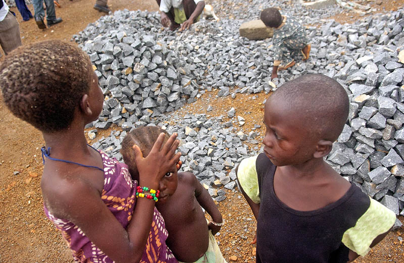 Sierra Leonean children gather at a rock quarry in Lakka just south of the capital Freetown. Children as young as three years old crush rocks in to gravel for sale to construction companies.