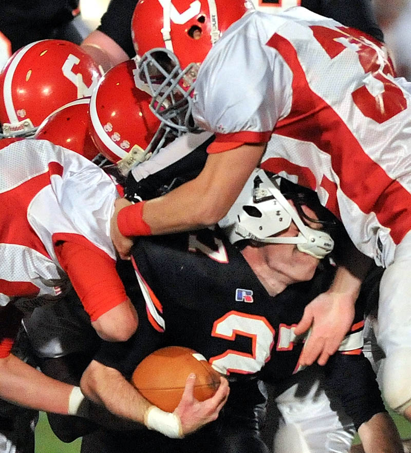 Skowhegan High School running back Adam Dusty, center, is tackled by Cony High School defenders during the second quarter Friday night in Skowhegan.