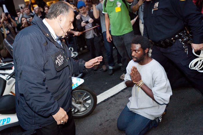 A police officer warns a protester of impending arrest if he does not move from the path of police scooters, as hundreds of Occupy Wall Street protesters march on the financial district after being heartened by a postponement of a scheduled cleanup of their camp at Zuccotti Park today.