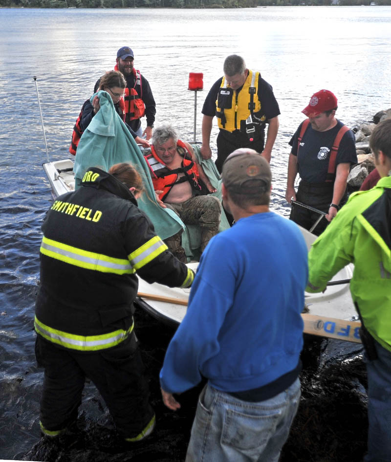Rescue personnel from Oakland, Smithfield and Belgrade arrive at the shore with a victim of a boat accident that occurred on North Pond just after 4 p.m. on Wednesday. The victim was transported to Inland Hospital in Waterville.