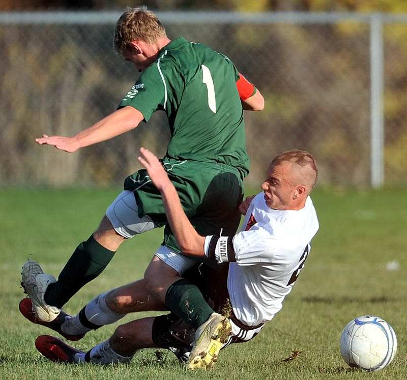 Staff photo by Michael G. Seamans Winslow High School's MacKenzie Michaud, 21, right, slide tackles Mt. View High School's Aaron Elkins, 1, in the second half of an Eastern B quarterfinal game at Kennebec Savings Bank Field in Winslow. Mt. View defeated Winslow 3-0.