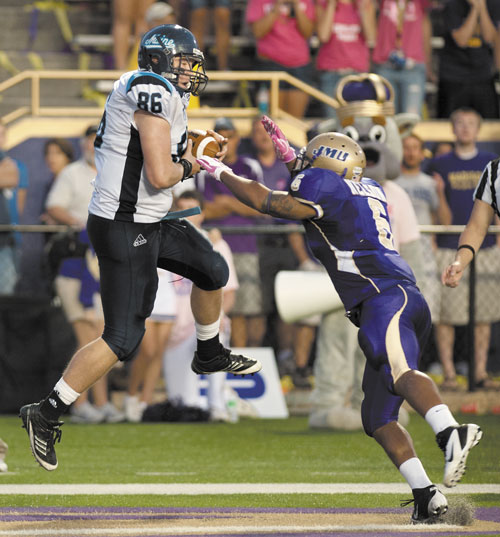 IT’S GOOD: Maine tight end Justin Perillo catches a touchdown pass as James Madison’s Vidal Nelson defends in overtime Saturday in Harrisonburg, Va. Maine quarterback Chris Treister scored on a two-point conversion to give Maine the victory 25-24.