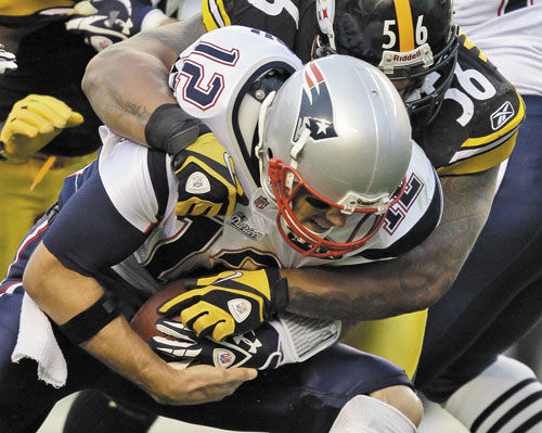 GOING DOWN: Pittsburgh Steelers linebacker LaMarr Woodley (56) sacks New England Patriots quarterback Tom Brady during the second quarter Sunday in Pittsburgh.