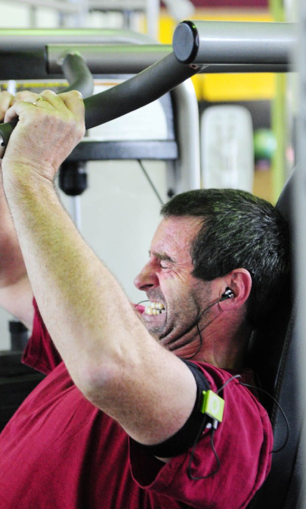 APPLE'S REACH: Vinnie McGuire lifts weights while he listens to music from the Apple iPod shuffle strapped on his arm on Thursday at the Planet Fitness in Augusta.