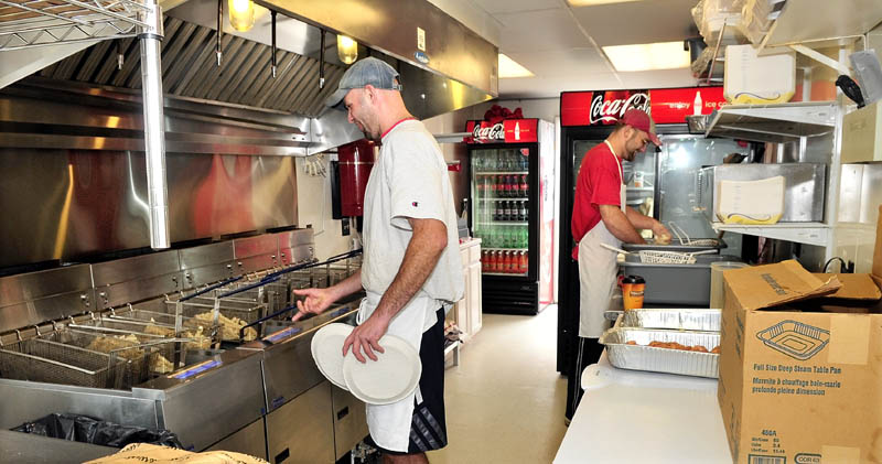 EXPANDING THE BUSINESS: Manager Shane Benedict, left, and employee Jeremy Bailey prepare food orders Wednesday at The Red Barn, a drive-through restaurant that opened recently on Bay Street in Winslow. The drive-through occupies a 10-foot-by-30-foot building that’s seen multiple food tenants in recent years.