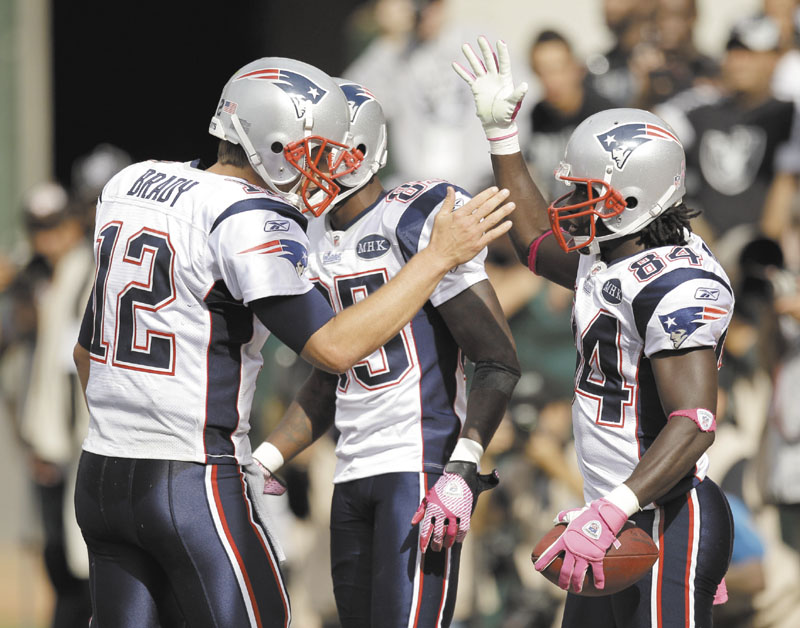 WAY TO GO: New England quarterback Tom Brady, left, greets wide receiver Deion Branch (84) after Branch caught a 4-yard pass for a touchdown in the fourth quarter of the Patriots’ 31-19 win over the Oakland Raiders on Sunday in Oakland, Calif. NFLACTION11;