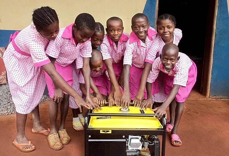 CHARGED UP: Students at the Mission School of Hope in the eastern region of Cameroon stand with a generator that will allow them to plug in computers and video chat with students at Carrabec Community School in Anson.