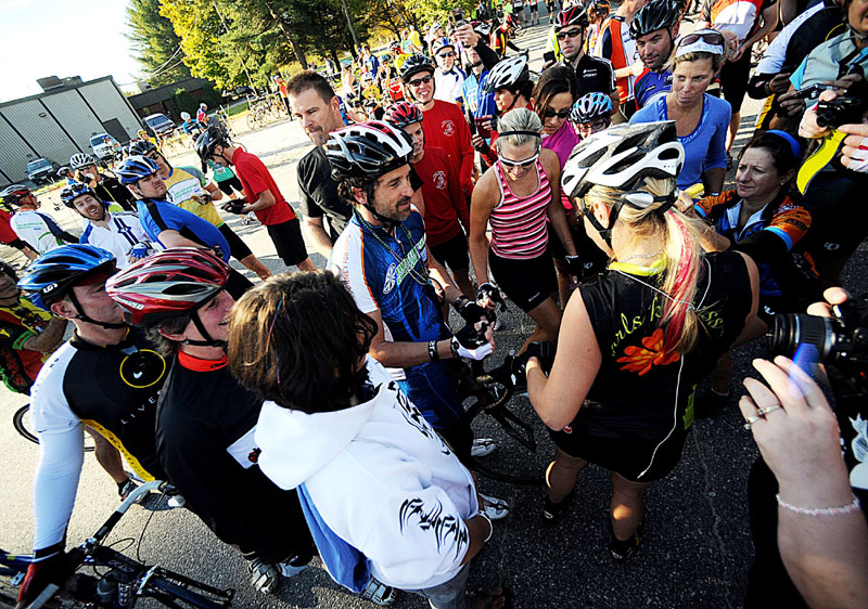 SWARMED: Actor Patrick Dempsey, center, is swarmed by fans Sunday at the first rest stop in the parking lot of Thos. Moser in Auburn on the cycling route of the Dempsey Challenge. Dempsey signed jerseys, bib numbers and also took countless photos with people along the 50 miles he biked.