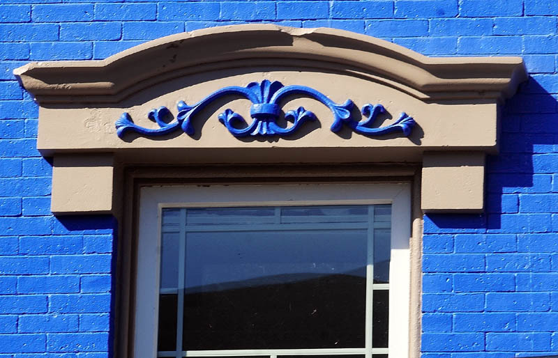 VIVID DISPLAY: One of Richard and Janet Parkhurst’s buildings is halfway through a bright blue paint job, with tan trim featuring trim details also painted in blue.