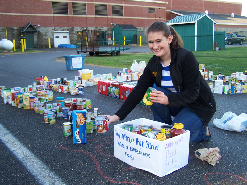 Maureen Tierney lines up cans and other items donated to the Make a Difference Day collection at Winthrop middle and high schools on Friday. The food was delivered to the Winthrop Food Pantry.