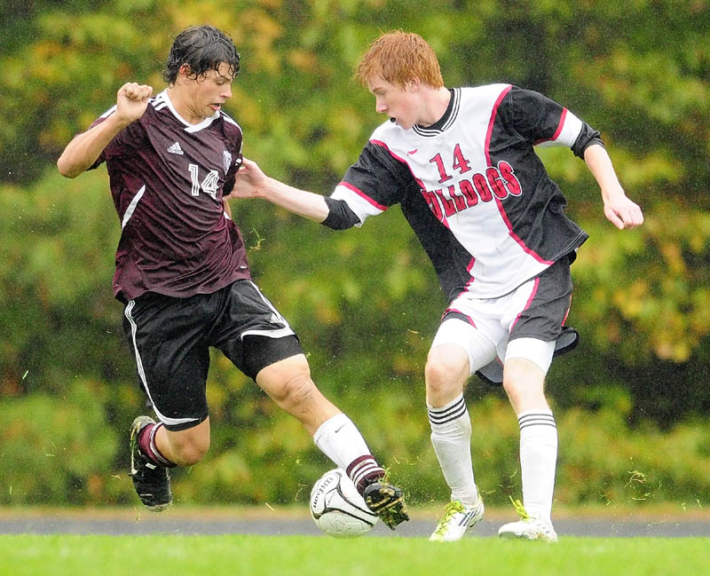 Monmouth Academy’s Russell Neal, left, and Hall-Dale’s Colin Lush battle for the ball during a game on a rainy Thursday afternoon at Hall-Dale High in Farmingdale.