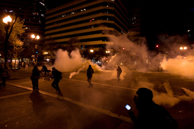 PROTEST TURNS UGLY: Occupy Wall Street protesters run from tear gas deployed by police Tuesday night in Oakland, Calif. The clash between Oakland police and protesters left a Marine veteran who served two Iraq tours in critical condition after he was struck by a police projectile, a veterans group said.