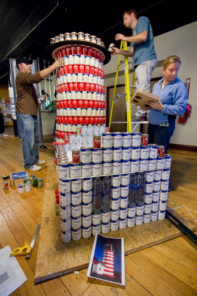 COMPETING: Members of Oak Point Associates of Biddeford construct a replica of West Quoddy Head Light out of cans during a Canstruction competition in downtown Biddeford on Saturday.
