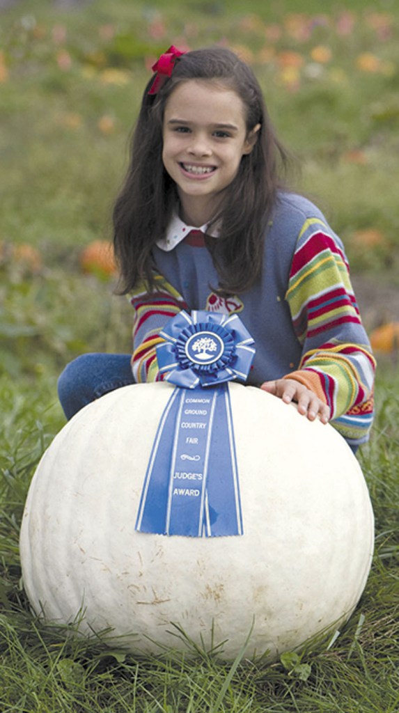 NOW THAT'S A PUMPKIN: Sienna Mazone, 9, of Dresden, won first prize for a 65-pound white pumpkin grown using Johnny’s Selected Seeds of Winslow in the Great Pumpkin Competition at the Common Ground Country Fair recently.