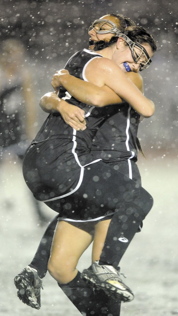 WE DID IT: Jessie Skillings, left, shares a celebratory hug with teammate Makaela Michonski after Skowhegan defeated Marshwood 5-0 to win the Class A field hockey state championship on Saturday in Yarmouth.