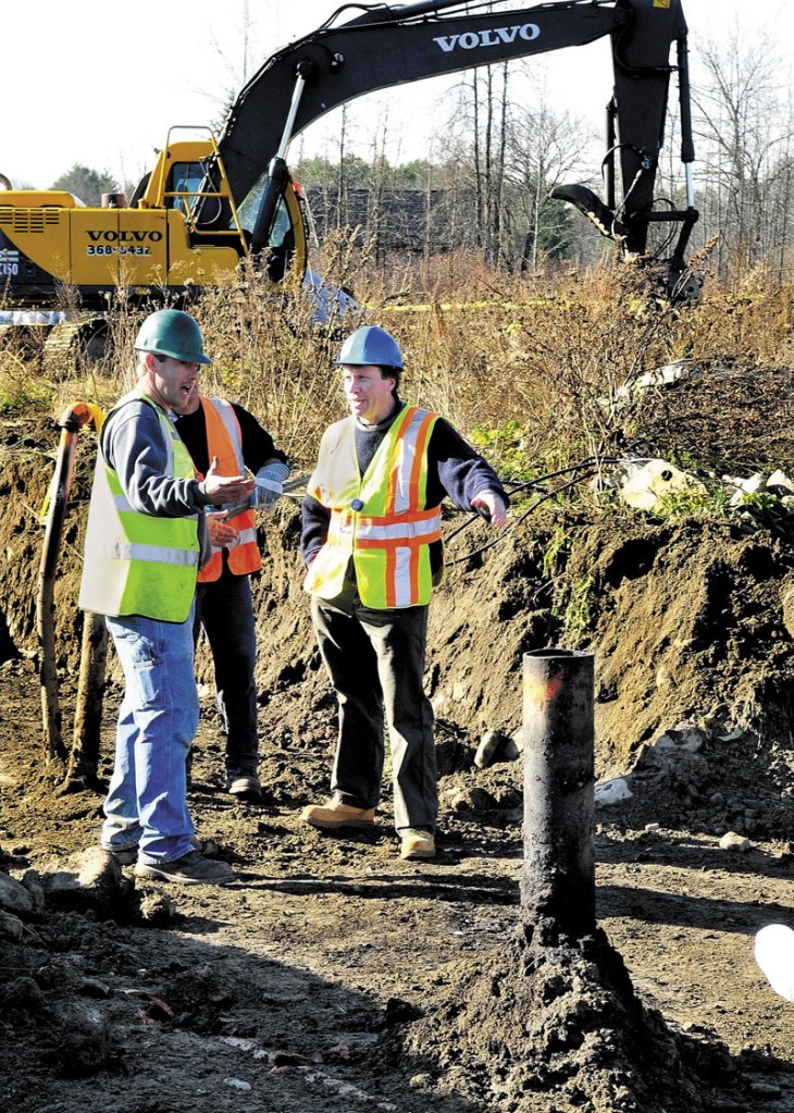 CLEANUP: Butch Bowie, right, an environmental specialist with the Maine Department of Environmental Protection, speaks with cleanup crews beside one of six underground waste oil tanks at the former J&A Floral shop in Benton on Wednesday.